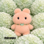 Plush pendant with 'Hydrangea' name tag among light green hydrangea flowers