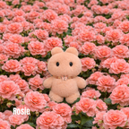 Plush pendant with 'Rosie' tag among pink flowers