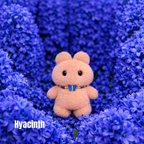 Plush pendant with 'Hyacinth' name tag among royal blue hyacinth flowers